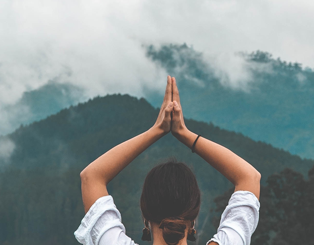 A person with her hands together over her head

Description automatically generated